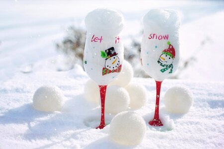Two White-and-red Snowman-printed Wine Glasses on Snow photo