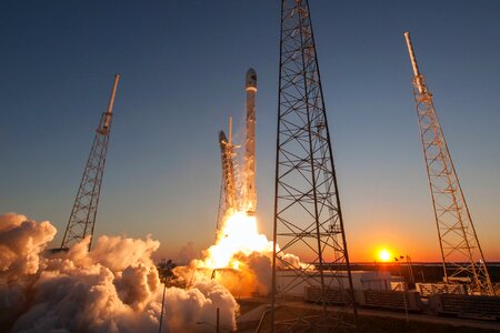 Spacecraft launching into orbit during sundown photo