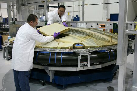 Professional mechanics installing spaceship detail at factory photo
