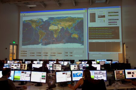 Group of colleagues working in modern office with big map on screen
