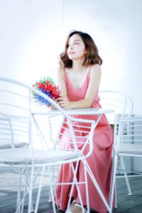 Woman In Pink Dress Sitting On Chair photo