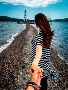 Woman In Stripes Holding Hands With Person Wearing Bracelets photo