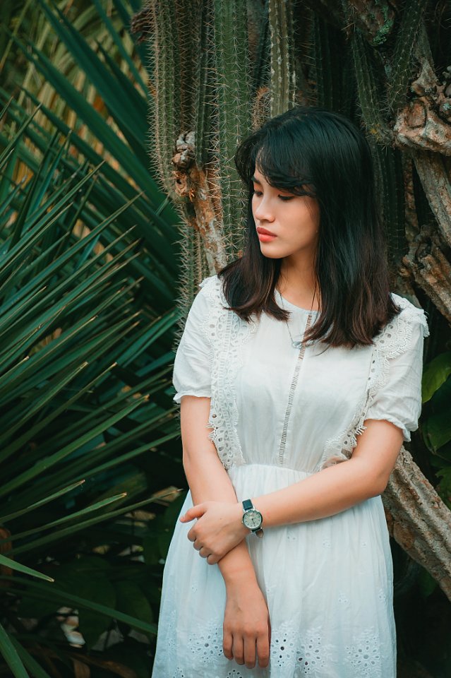 Woman Wearing A Teal Half-sleeved Dress Standing Beside Green Plant