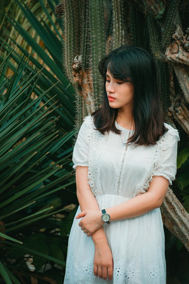 Woman Wearing A Teal Half-sleeved Dress Standing Beside Green Plant photo