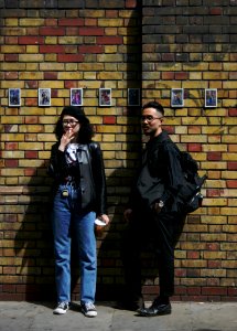 Man And Woman Standing In Front Of Concrete Wall photo