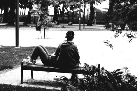Grayscale Photo Of A Couple Sitting On A Bench photo