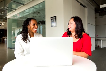 Two Women In Front Of Silver Macbook photo