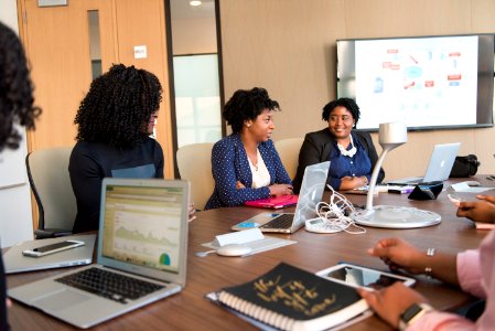 Women Gathered On Table Near Monitor photo