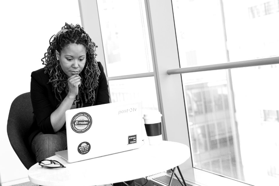 Grayscale Photo Of Woman Facing Macbook