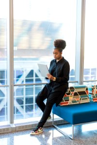 Woman In Black Jacket Standing Near Blue Sofa