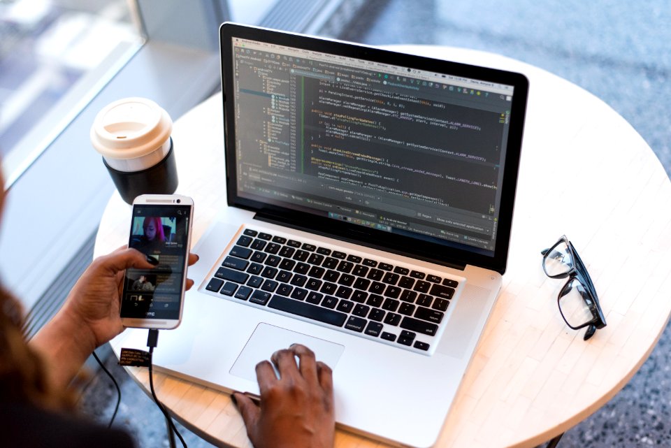 Person Hold Gold Htc Android Smartphone In Front Of Macbook Pro