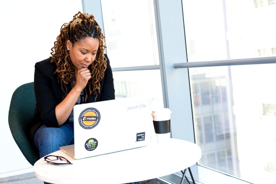 Woman In Black Coat In Front Of White Laptop Computer