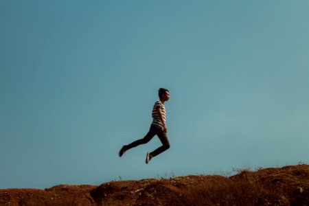 Man Jumping Near The Cliff photo