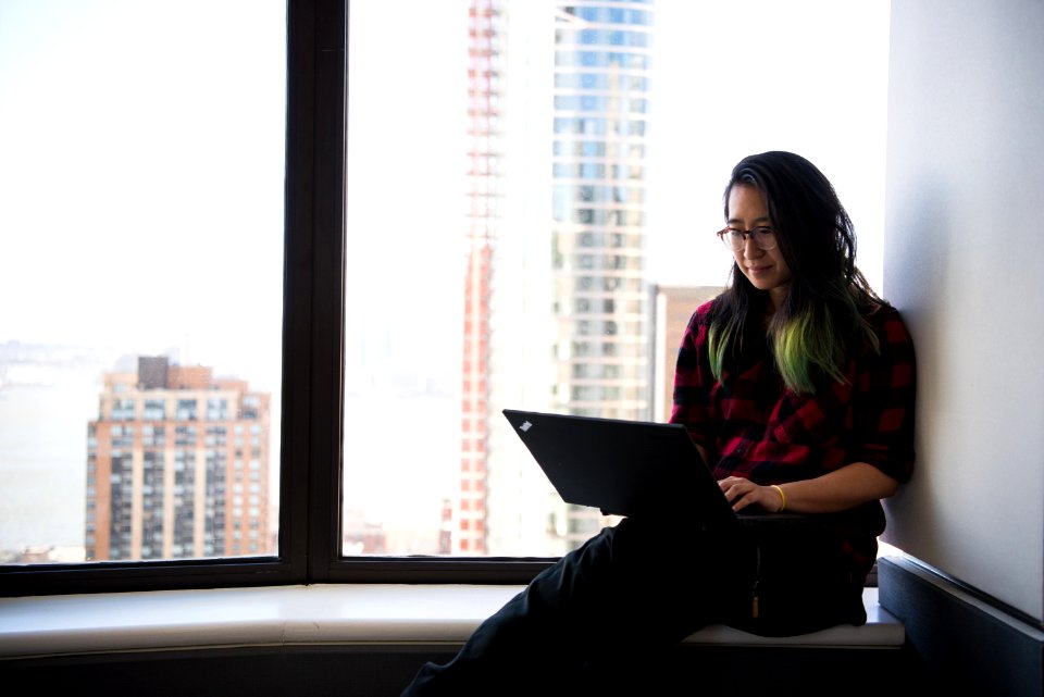 Woman Wearing Red Elbow-sleeved Shirt And Black Pants Sitting Beside Window photo