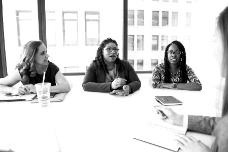 Four Women Sitting Near Table photo