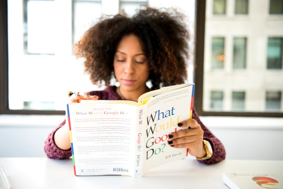 Woman Wearing Maroon Crochet Long-sleeved Shirt Reading What Would Google Do Book