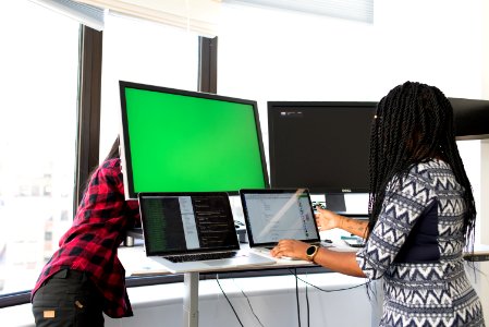 Woman Wearing White Gray And Black Elbow-sleeved Dress Using Macbook Pro photo