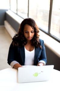 Tilt-shift Photography Of Woman In Blue Formal Coat With White Laptop Computer