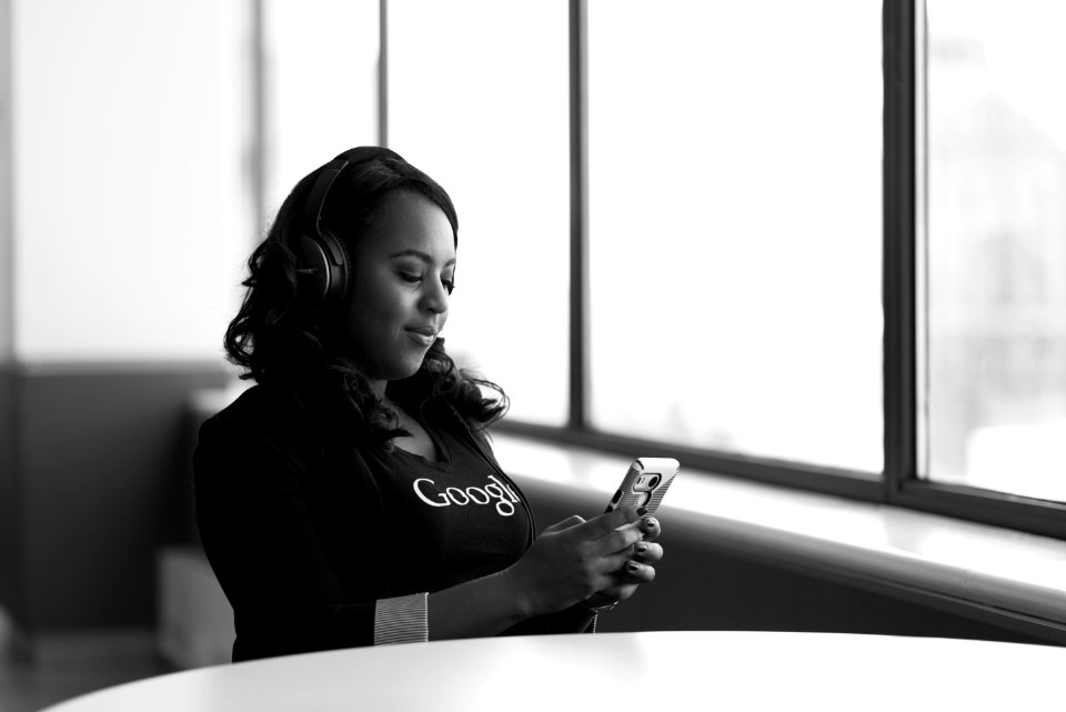 Greyscale Photo Of Woman Holding A Smartphone photo