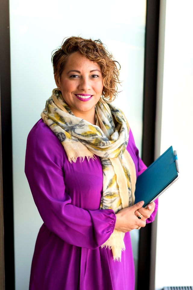 Woman Smiling And Holding Teal Book