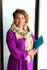 Woman Smiling And Holding Teal Book photo