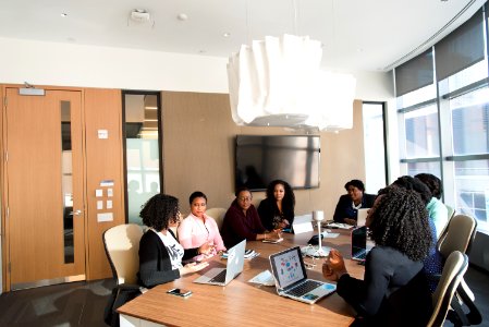 People Sitting Around Brown Wooden Table Under White Pendant Lamp Inside Room photo