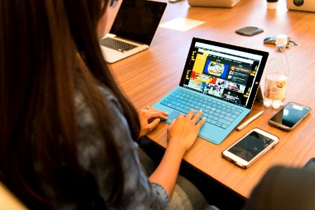 Woman In Gray Long-sleeved Top Using Laptop photo