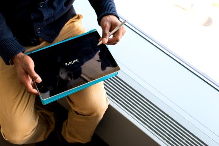 Person Wearing Brown Pants Holding Black Tablet Computer