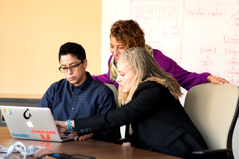 Closeup Photo Of Three Person Looking At Macbook Air