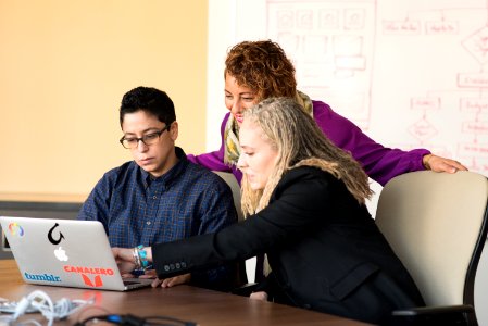 Closeup Photo Of Three Person Looking At Macbook Air