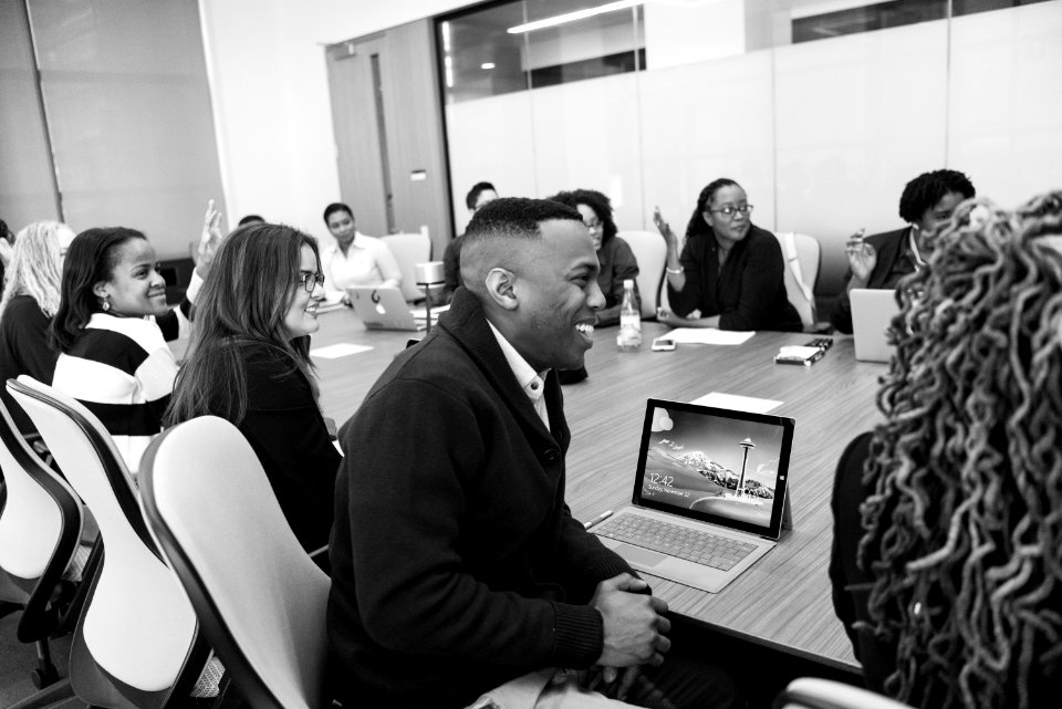 Group Of People Sitting In Conference Table Laughing