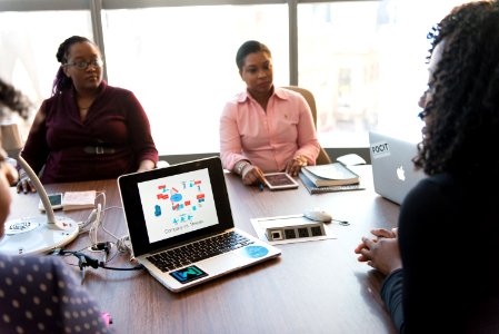 Four Women Sitting On Chair And Taking Talk Over