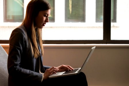 Woman Sitting Down And Using Laptop On Her Lap photo