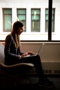 Woman Sits And Use Laptop Computer Near Window photo