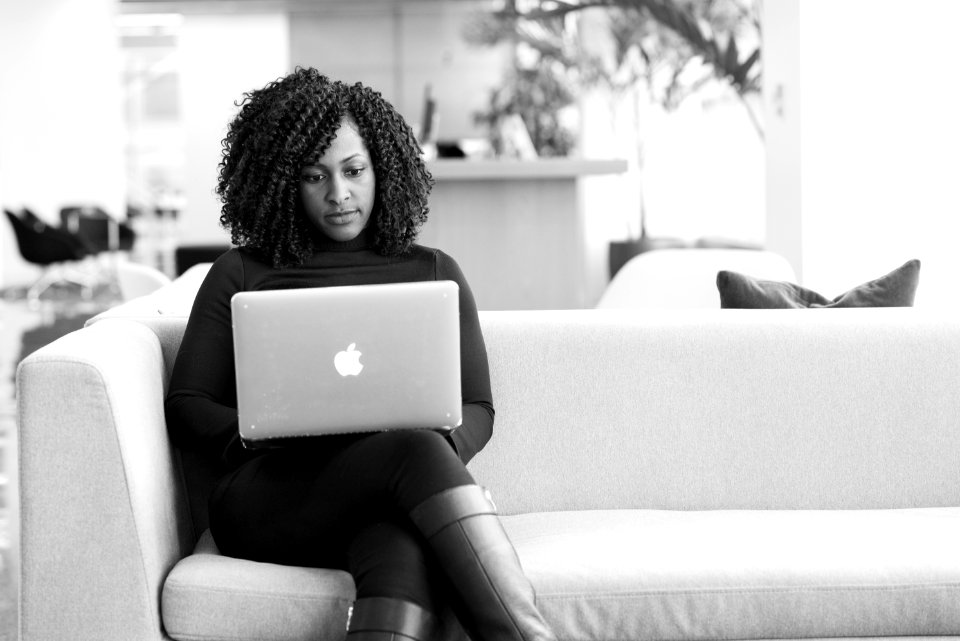 Woman Sitting On Couch Using Macbook photo