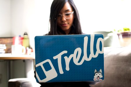 Woman Wearing Eyeglasses Using Blue And And Gray Laptop Inside Room photo