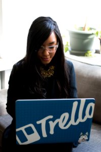 Woman In Black Coat Holding Her Blue Laptop Computer