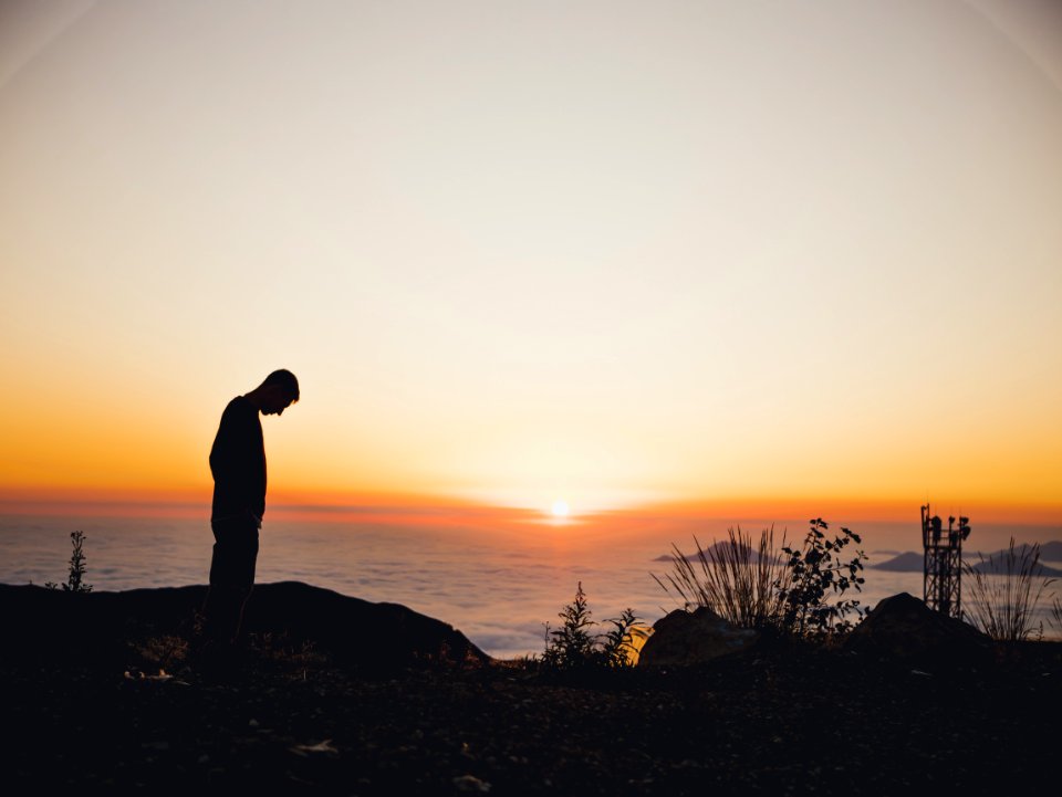 Silhouette Of Man Standing Near Sea During Golden Hour