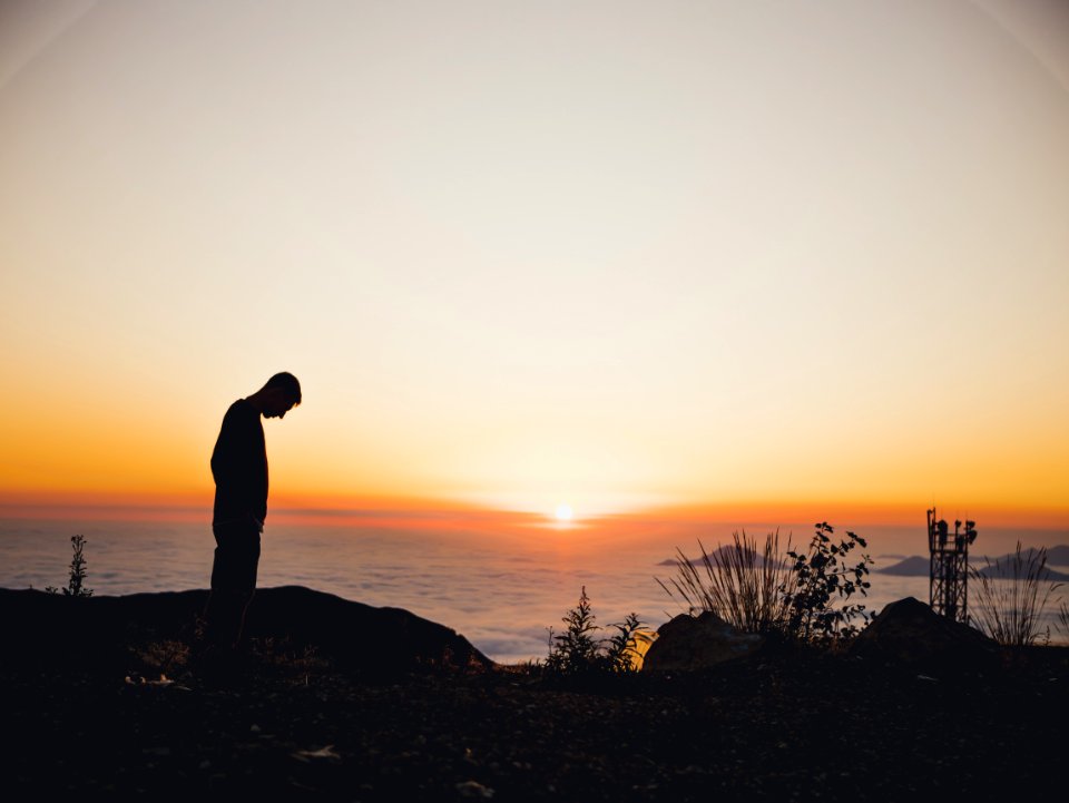 Silhouette Of Man Standing Near Sea During Golden Hour photo