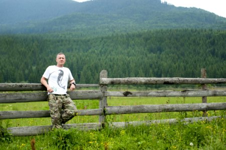 Photo Of Man Leaning On Wooden Fence photo