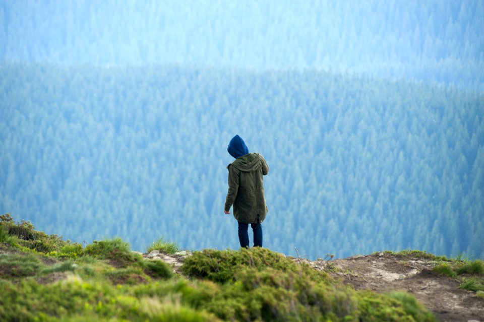 Person In Green Jacket Standing On Cliff