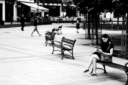 Grayscale Photography Of Woman Sitting While Reading Book photo
