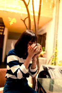 Woman Seated Outside Drinking From A Brown Bowl photo