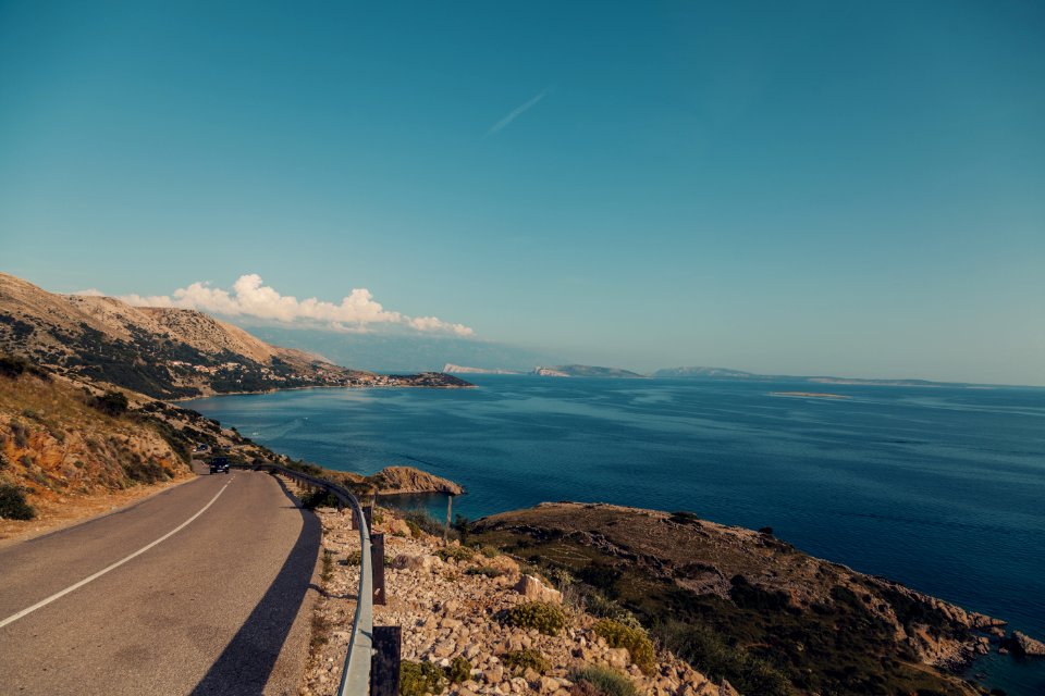 Empty Road Near Calm Body Of Water