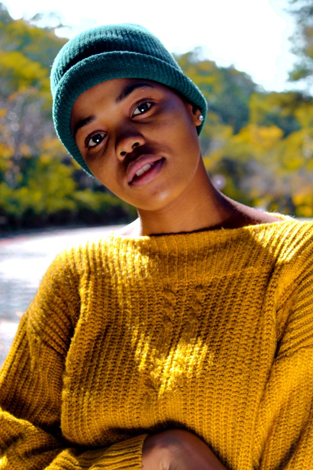 Woman Wearing Yellow Knit Sweater And Blue Knit Hat