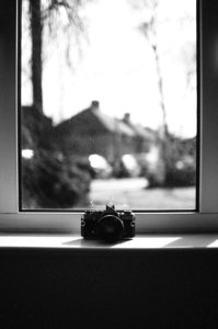 Grayscale Photo Of Camera Beside Window photo