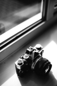 Grayscale Photo Of Classical Camera Near Window photo