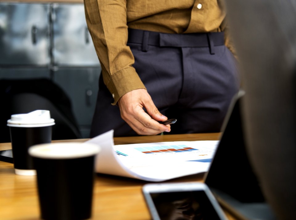 Person In Brown Dress Shirt And Black Bottoms Near Brown Wooden Desk photo