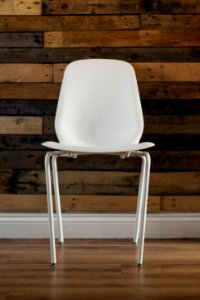 White Plastic Chair Beside Brown Wooden Wall In Home photo