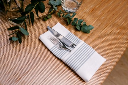 Silver Fork And Knife Inside Gray And White Table Napkin On Table photo